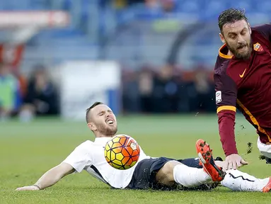 Pemain AS Roma, Daniele De Rossi, terjatuh akibat tekel pemain Atalanta, Jasmin Kurtic, pada laga Serie A di Stadion Olimpico, Italia, Minggu (29/11/2015). Roma kalah 0-2. (Reuters/Giampiero Sposito) 