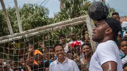 Mantan pesebak bola dunia Didier Drogba menunjukkan keahliannya saat mengikuti acara amal organisasi internasional Peace and Sport, di Cartagena, Kolombia (19/3). (Cesar Carrion/Colombian Presidency/AFP)