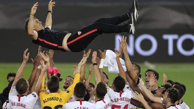 Pemain Sevilla mengangkat sang pelatih, Julen Lopetegui, usai mengalahkan Inter Milan pada laga final Liga Europa 2019/2020 di Stadion RheinEenergie, Sabtu (22/8/2020) dini hari WIB. Sevilla menang 3-2 atas Inter Milan. (AFP/Friedemann Vogel/pool)