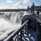 Es dan air mengalir di tepi Horseshoe Falls dari Air Terjun Niagara di Ontario, Kanada, Kamis (31/1). Walaupun Niagara tetap mengalir namun beberapa bagian sungai yang membeku menciptakan keindahan di lokasi itu. (Tara Walton/The Canadian Press via AP)