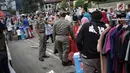 Satpol PP DKI Jakarta menertibkan PKL yang berdagang di kawasan Car Free Day, Bundaran HI, Jakarta, Minggu (20/1). Penertiban dilakukan karena telah membuat ketidaknyamanan bagi para pengunjung CFD yang ingin berolahraga. (Liputan6.com/Faizal Fanani)