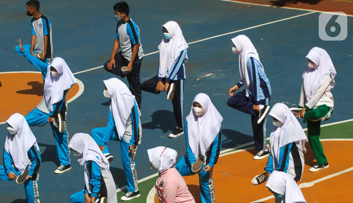 Siswa mengikuti pelajaran olahraga pada hari pertama pembelajaran tatap muka di SMP 26 Depok, Depok, Jawa Barat, Senin (24/1/2022). Pemerintah Kota Depok mulai menggelar Pembelajaran Tatap Muka (PTM) secara penuh atau 100 persen mulai hari ini. (Liputan6.com/Herman Zakharia)