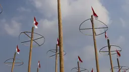 Pekerja memasang bendera Merah Putih pada pohon pinang untuk acara panjat pinang kolosal di kawasan Ancol, Jakarta, Kamis (15/8/2019). Ancol Taman Impian memasang sebanyak 174 batang pohon pinang untuk meriahkan Hari Kemerdekaan dengan tema " Pesta Manusia Merdeka". (Liputan6.com/Herman Zakharia)