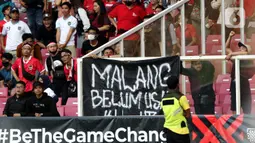 Pendukung timnas Indonesia membentang spanduk bertuliskan “Malang Belum Usai” saat menyaksikan laga kualifikasi Grup A Piala AFF 2022 antara Indonesia melawan Kamboja di di Stadion Utama Gelora Bung Karno, Jakarta, Jumat (23/12/2022). Mereka menyuarakan pengusutan tuntas kasus atas Tragedi Kanjuruhan yang terjadi pada awal Oktober 2022 lalu. (Liputan6.com/Helmi Fithriansyah)