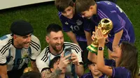 Pemain Argentina Lionel Messi memotret istrinya Antonela Roccuzzo yang memegang trofi Piala Dunia 2022 usai mengalahkan Prancis pada pertandingan sepak bola final Piala Dunia 2022 di Stadion Lusail, Lusail, Qatar, 18 Desember 2022. Argentina menang 4-2 atas Prancis melalui drama adu penalti setelah pertandingan berakhir imbang 3-3. (AP Photo/Francisco Seco)