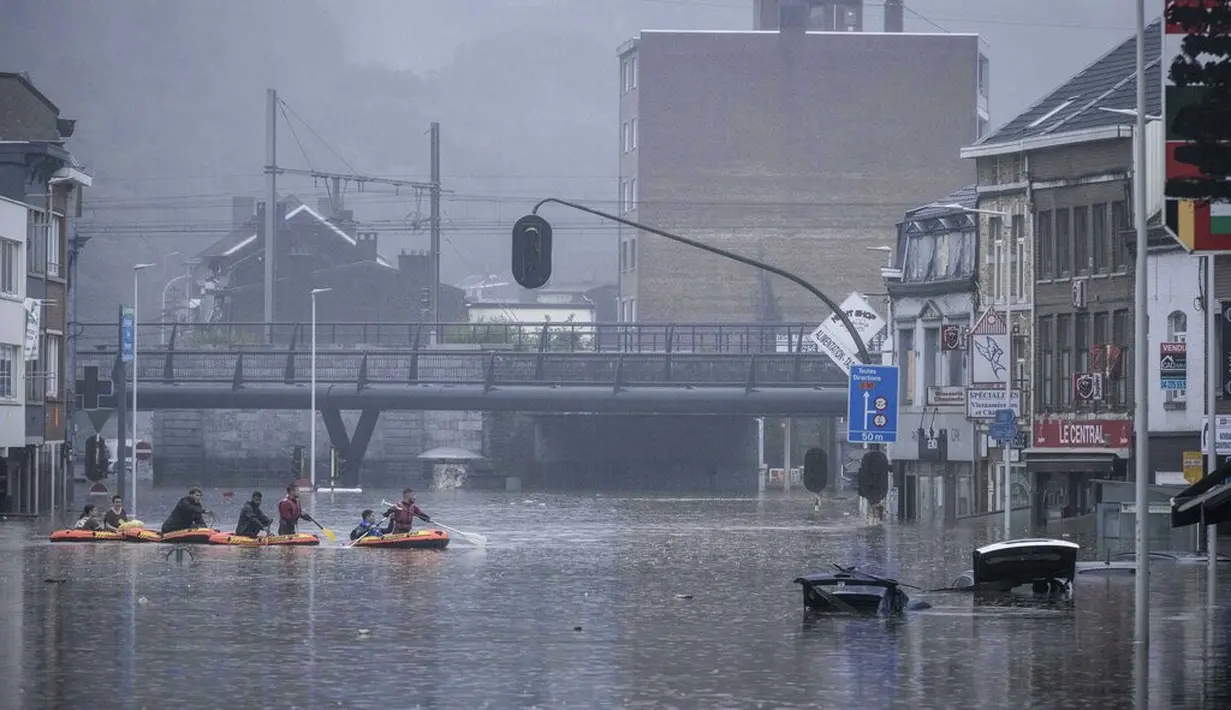 Warga menggunakan rakit karet di tengah banjir setelah Sungai Meuse jebol saat banjir besar di Liege, Belgia, Kamis (15/7/2021). Curah hujan yang tinggi menyebabkan banjir di beberapa provinsi di Belgia dengan hujan diperkirakan berlangsung hingga Jumat. (AP Photo/Valentin Bianchi)