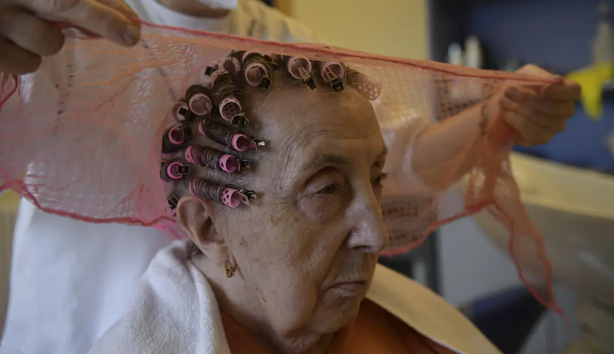 Maribel Elizondo, 90 tahun, ditata rambutnya oleh penata rambut Gloria Cerdan di salon rambut di panti jompo Ibaneta, sekitar 30 km dari Pamplona, Spanyol, Senin (22/3/2021). Setiap minggu, pada hari Senin, penata rambut Gloria Cerdan mendatangi penghuni panti jompo. (AP Photo/Alvaro Barrientos)