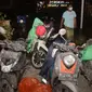 Seorang warga berjalan melewati sepeda motor para pengungsi yang diselimuti abu vulkanik pasca erupsi Gunung Semeru di desa Sumberurip, Lumajang (4/12/2021). Wakil Bupati Lumajang Indah Masdar melaporkan ada satu orang yang meninggal dunia akibat erupsi Gunung Semeru. (AFP/Juni Kriswanto)