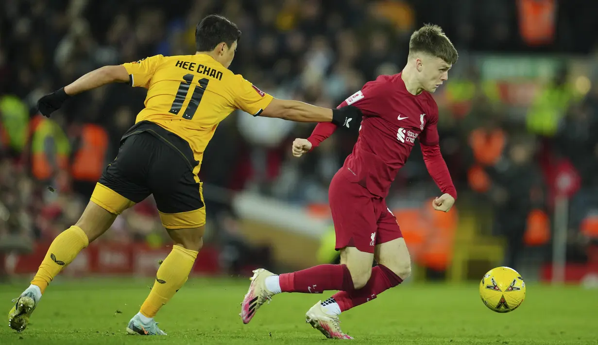 <p>Penyerang Liverpool, Ben Doak berusaha melewati penyerang Wolverhampton Wanderers, Hwang Hee-chan selama pertandingan putaran ketiga Piala FA di stadion Anfield, Inggris, Minggu (8/1/2023). Liverpool bermain imbang dengan Wolves dengan skor 2-2. (AP Photo/Jon Super)</p>