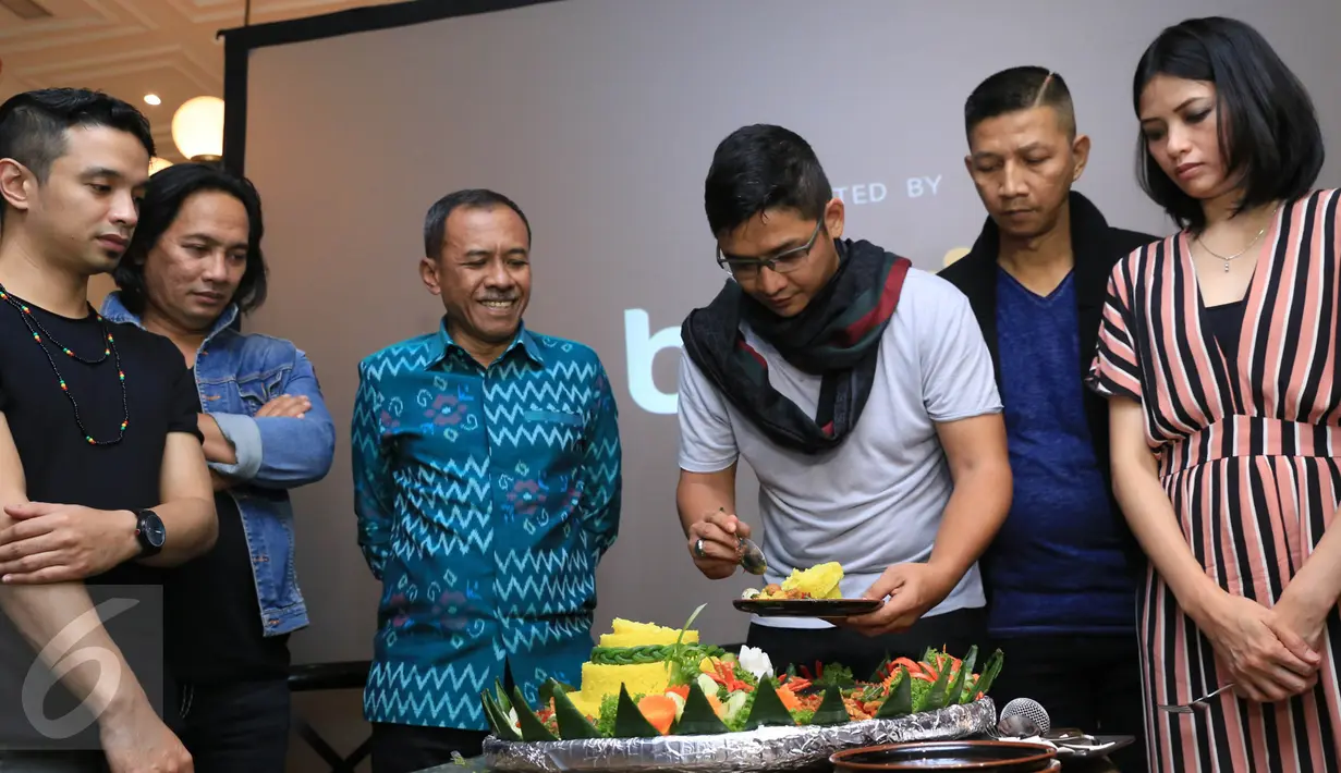 Vokalis band Ungu, Pasha memotong tumpeng saat jumpa pres singel terbaru di kawasan Kota Kasablanka, Jakarta, Kamis (9/3). Band Ungu mengeluarkan single terbaru bertajuk Setengah Gila .(Liputan6.com/Herman Zakharia)