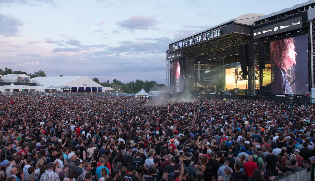 Ribuan penonton menyaksikan aksi panggung Metallica saat tampil di Festival d'ete de Quebec di Quebec City, Kanada (14/7). Ribuan penonton terhibur dengan aksi panggung band metal tersebut. (AFP Photo/Alice Chicheby)