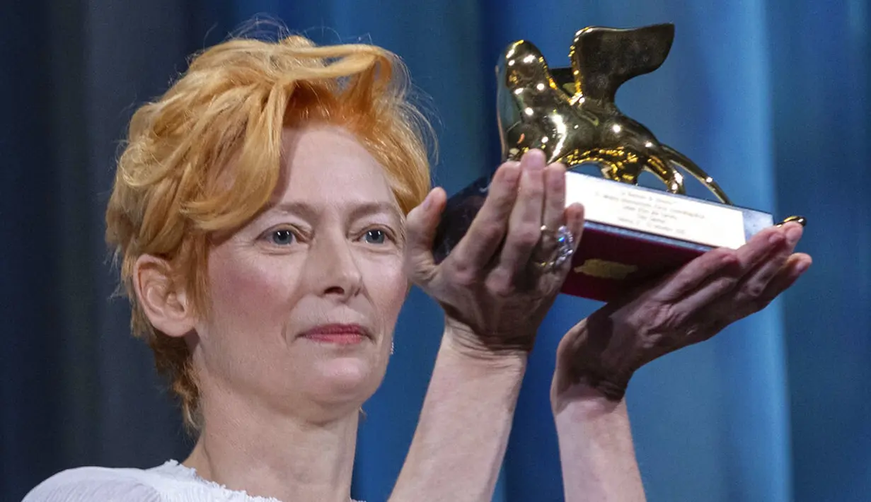 Aktris Tilda Swinton memegang trofi Golden Lion for Lifetime Achievement pada upacara pembukaan Venice Film Festival ke-77 di Venesia, Italia, Rabu (2/9/2020). Venice Film Festival tahun ini akan berlangsung dari 2 September hingga 12 September. (AP Photo/Domenico Stinellis)