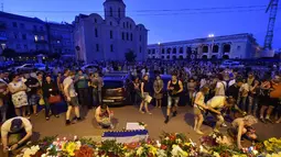 Sejumlah warga meletakan karangan bunga lilin sebagai ungkapan belasungkawa atas jatuhnya pesawat Malaysia Airlines MH-17 di Ukraina, Jumat (17/7/14). (AFP PHOTO/Sergei Supinsky)