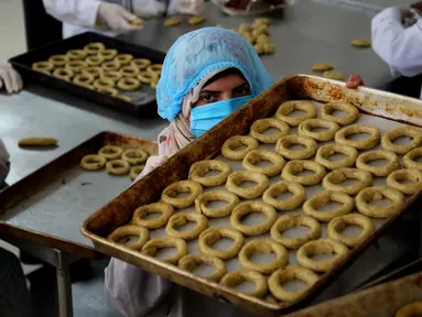Para perempuan Palestina menyiapkan kue tradisional untuk dijual di asosiasi wanita setempat menjelang Idul Fitri untuk merayakan akhir bulan suci Ramadan di tengah karantina wilayah (lockdown) akibat epidemi COVID-19 di Kota Beit Lahia, Jalur Gaza utara, pada 17 Mei 2020. (Xinhua/Rizek Abdeljawad)