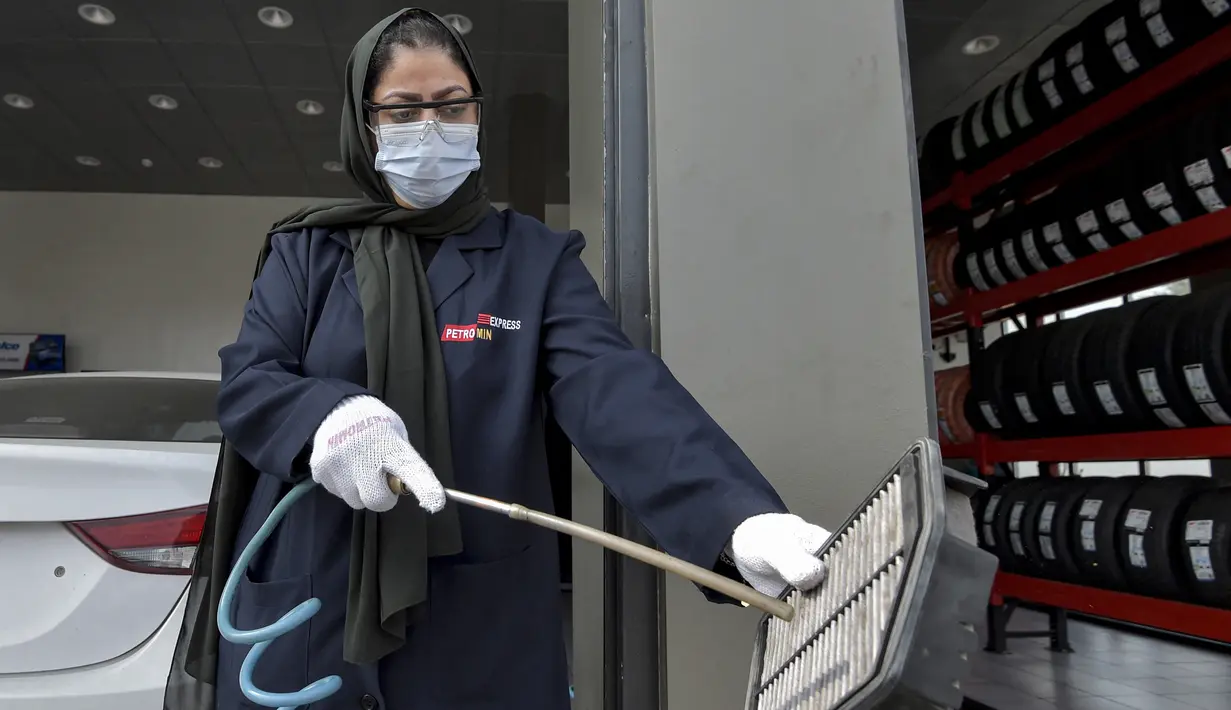 Seorang mekanik wanita Saudi membersihkan saringan udara bagian mobil di bengkel perbaikan dan servis di kota Jeddah, Arab Saudi (27/12/2021). Melalui program Vision 2030, kini semakin banyak wanita di Arab Saudi yang bekerja di bidang baru, seperti pramugari dan pengemudi taksi. (AFP/Amer Hilabi)