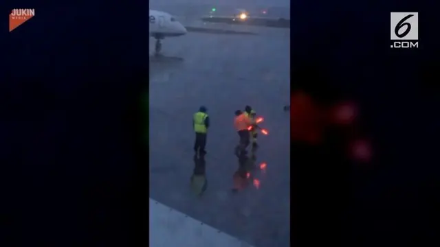 Dua juru parkir pesawat berkelahi di tengah-tengah apron menggunakan tongkat menyala berwarna oranye