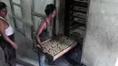 Pekerja mengeringkan rokok linting atau beedi ke dalam tungku di sebuah pabrik di Nizamabad, India, 10 Oktober 2019. Saat ini penggemar beedi di India sudah mencapai 70 juta orang. (NOAH SEELAM/AFP)