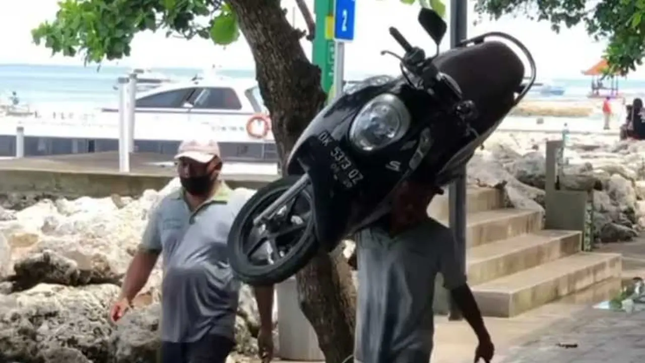 Orang ini gendong motor di pinggir pantai di Bali (Dagelan)