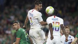 Pemain Amerika Serikat, Matt Miazga (tengah) membuang bola dari kejaran pemain Irlandia pada laga uji coba di Aviva Stadium, Dublin, (2/6/2018). Irlandia menang 2-1. (Brian Lawless/PA via AP)