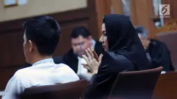 Bupati nonaktif Kutai Kartanegara, Rita Widyasari (kiri) saat mengikuti sidang perdana di Pengadilan Tipikor, Jakarta, Rabu (21/2). Rita didakwa dalam dugaan suap pemberian izin lokasi perkebunan kelapa sawit. (Liputan6.com/Helmi Fithriansyah)
