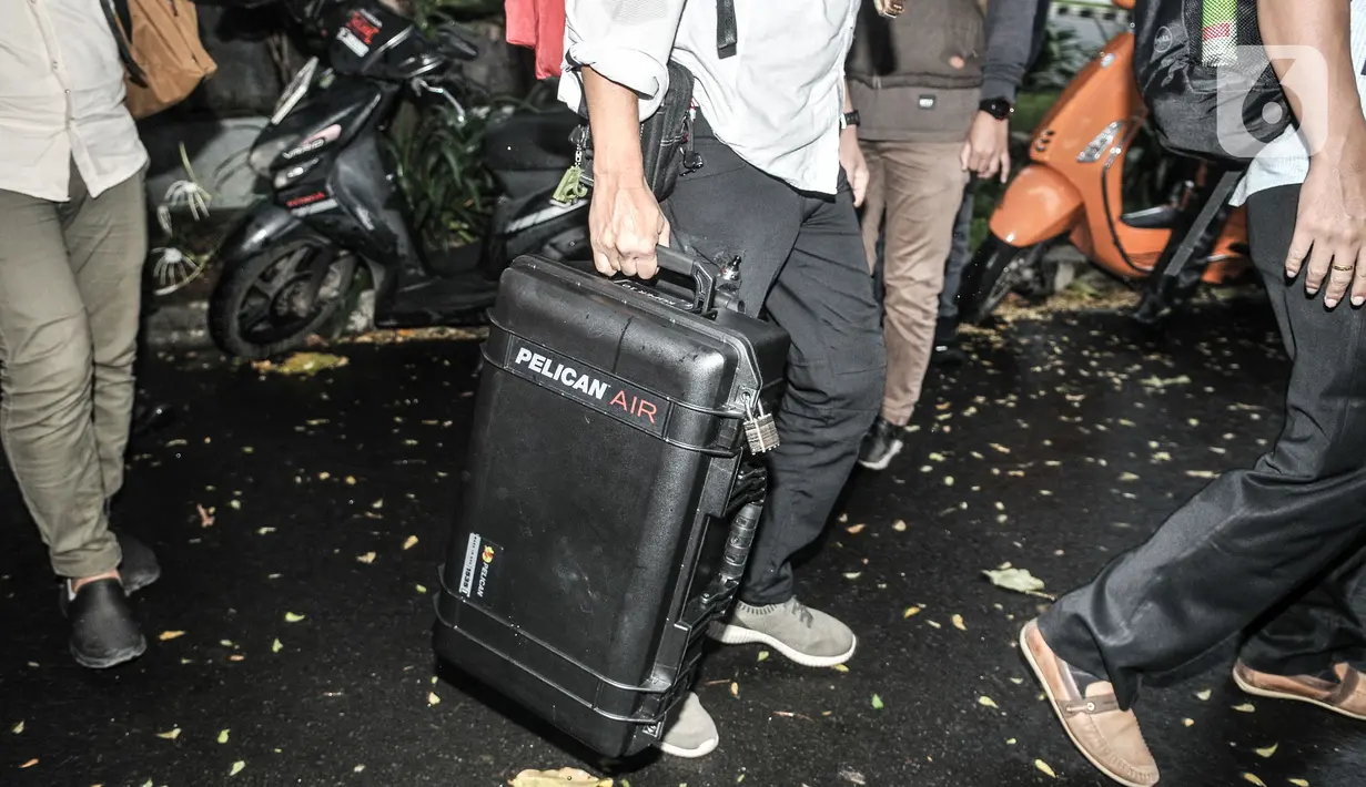 Penyidik KPK membawa koper usai menggeledah kediaman politisi PDIP Ihsan Yunus di kawasan Kayu Putih, Pulogadung, Jakarta, Rabu (24/2/2021). Dalam penggeledahan tersebut KPK mengerahkan 10 penyidik dan membawa dua koper saat keluar dari kediaman Ihsan Yunus. (merdeka.com/Iqbal S. Nugroho)