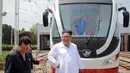 Pemimpin Korea Utara Kim Jong-Un tersenyum saat melihat kereta ringan selama kunjungan ke pabrik bus di Pyongyang, (4/8). Tak hanya bus, pabrik tersebut juga membuat kereta ringan atau trem. (AFP Photo/KCNA)