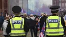 Petugas kepolisian melakukan patroli terhadap para fans Glasgow Rangers di luar Ibrox Stadium (7/3/2021) dalam perayaan keberhasilan tim kesayangan mereka merebut gelar Liga Utama Skotlandia setelah memimpin 20 poin dari saingan terdekat, Glasgow Celtic. (AFP/Andy Buchanan)