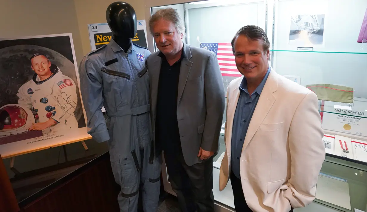 Dua putra Neil Armstong, Rick dan Mark, berpose dengan barang-barang milik ayahnya yang ditampilkan di Heritage Auctions, New York pada 2 Oktober 2018.  Berbagai jenis barang Armstrong dilelang pada 1 November 2018. (Don EMMERT/AFP)
