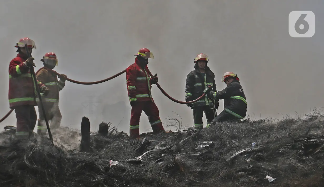 Petugas Pemadam Kebakaran Kabupaten Bogor memadamkan api di lapak ban bekas, Desa Bojong Nangka, Gunung Putri, Kamis (22/4/2021). Banyaknya bahan yang mudah terbakar dan sumber api yang berasal dari bawah tumpukan ban membuat  api di lokasi belum juga padam. (Liputan6.com/Herman Zakharia)