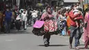 Pedagang kaki lima yang mengenakan masker menjual tas di Sunday marketdi Jammu, India, Minggu (11/4/2021). Para ahli di India meyakini perilaku menganggap remeh aturan jarak sosial serta mengenakan masker di ruang publik menjadi pola yang meningkatkan kasus COVID-19. (AP/Channi Anand)