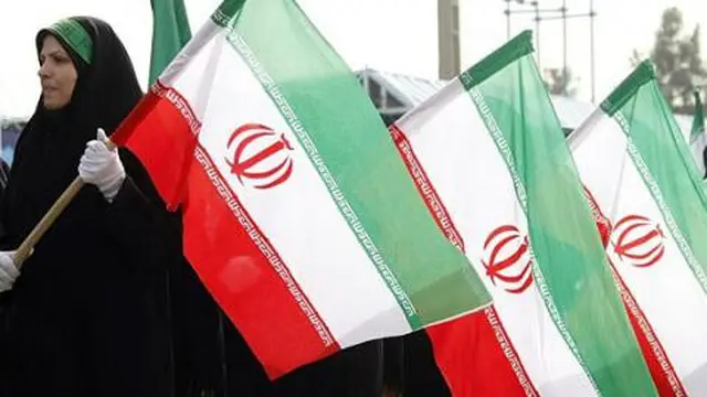 Beberapa perempuan membawa Bendera Iran di Ibu Kota Teheran. (c) AFP/Begriyz Negr