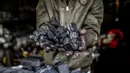 Seorang pekerja menunjukkan segenggam arang di fasilitas produksi arang al-Hattab, sebelah timur Kota Gaza, Palestina, 28 Januari 2021. Satu kilogram arang dijual seharga USD 1,50 di tempat dan USD 2,50 di pasar. (Mohammed ABED/AFP)