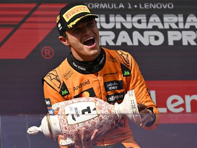 Pembalap McLaren, Lando Norris mengangkat trofi saat merayakan kemenangan dalam ajang balap Formula 1 GP Hungaria 2025 di sirkuit Hongaroring, Minggu (03/08/2025) waktu setempat. (AP Photo/Denes Erdos)
