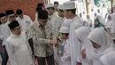 Menpora Imam Nahrawi bersalaman dengan anak-anak saat menghadiri pembukaan Nusantara Bertauhid di Ciganjur, Jakarta, Kamis (14/3). Kegiatan ini mengajak masyarakat berselawat dan mengkhatamkan Alquran. (Liputan6.com/Faizal Fanani)