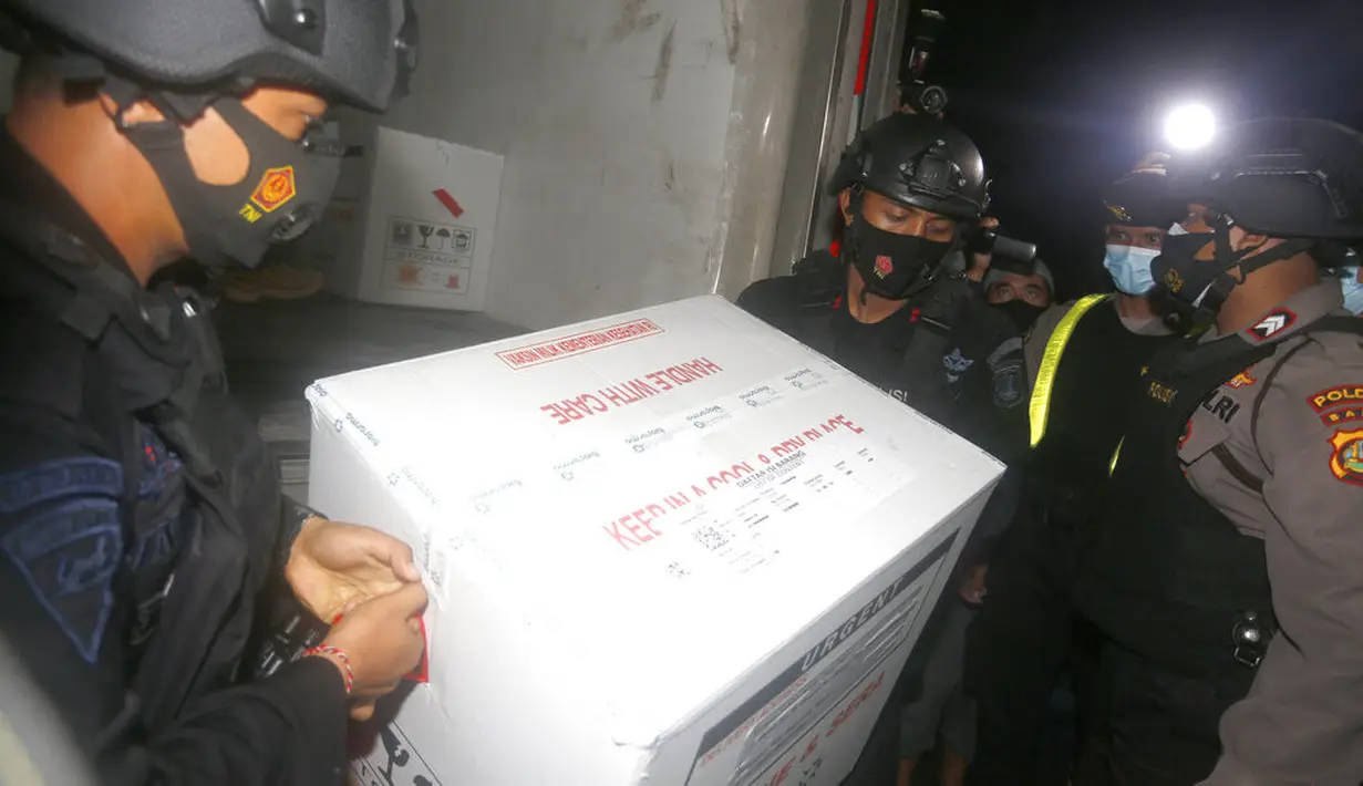 Petugas keamanan membawa kotak berisi vaksin virus corona COVID-19 setibanya di Bali, Selasa (5/1/2021). Vaksin virus corona COVID-19 tersebut masih menanti izin edar dari BPOM. (AP Photo/Firdia Lisnawati)