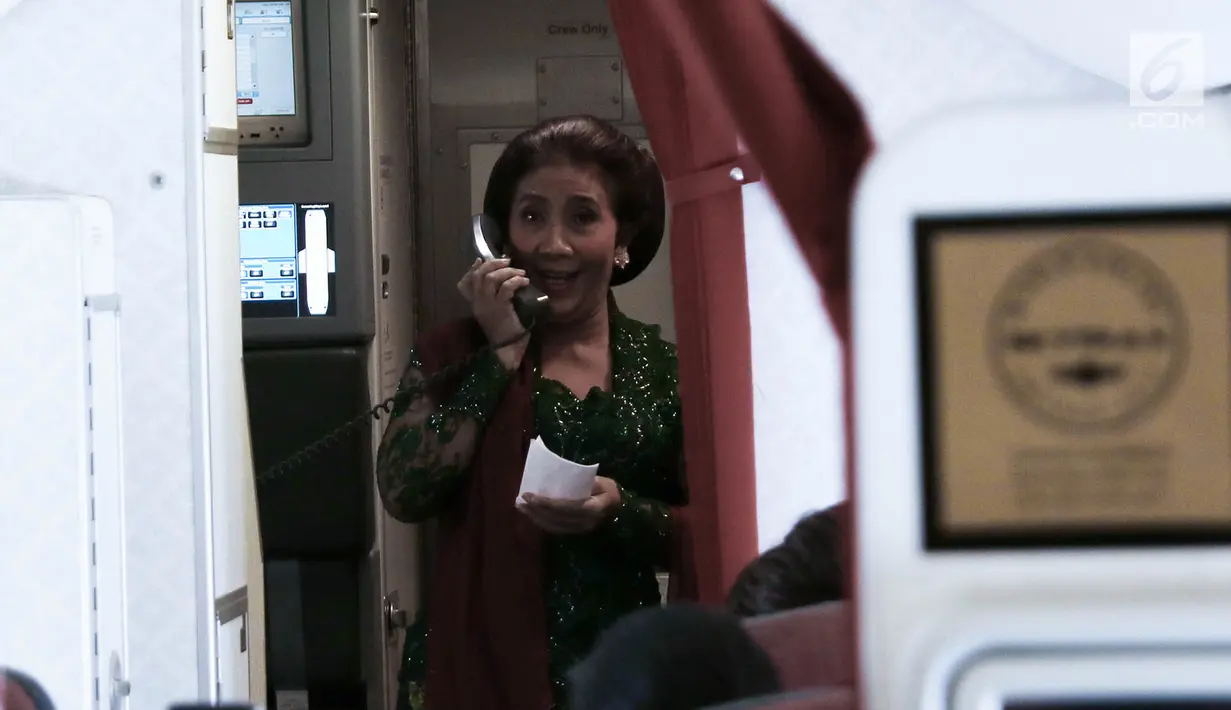 Aksi Menteri Kelautan dan Perikanan Susi Pudjiastuti sebelum mengikuti Kartini Flight di Bandara Soetta, Tangerang, Banten, Sabtu (21/4). Acara ini melibatkan awak kabin, petugas darat, dan pilot yang semuanya perempuan. (Liputan6.com/Immanuel Antonius)