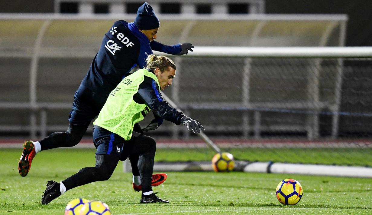 Striker Prancis, Kylian Mbappe dan Antoine Griezmann, berebut bola saat sesi latihan jelang laga persahabatan di Paris, Selasa (7/11/2017). Prancis akan berhadapan dengan Jerman dan Wales. (AFP/Franck Fife)