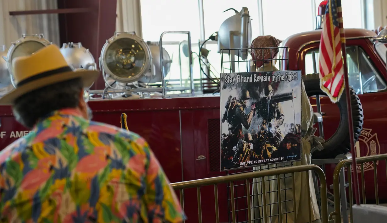 Pengunjung melewati poster Perang Dunia II yang diadaptasi untuk perjuangan melawan COVID-19 di Museum of American Armor di Plainview, New York, 15 Agustus 2020. Pameran poster Perang Dunia II yang kini diadaptasi itu untuk mengingatkan pengunjung agar waspada terhadap COVID-19. (Xinhua/Wang Ying)