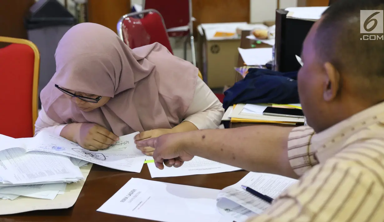 Petugas KPU mengecek berkas perbaikan daftar calon dan syarat calon anggota DPR yang diajukan perwakilan Parpol peserta Pemilu 2019 di Jakarta, Selasa (31/7). KPU membuka pengajuan perbaikan hingga pukul 23.59 WIB. (Liputan6.com/Helmi Fithriansyah)