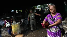 Seorang ibu menyelamatkan ayam peliharaannya saat proses penertiban bangunan liar dikolong tol Warakas, Jakarta, Kamis (11/8). Sebanyak 355 personil gabungan dikerahkan untuk menertibkan 80 bangunan liar di kawasan tersebut. (Liputan6.com/Faizal Fanani)