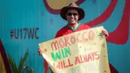 Suporter Maroko, Mohammad Aziz Mrabat berpose dengan membentangkan poster bertuliskan "Maroko, menang atau kalah aku tetap mencintaimu" menjelang laga kedua Grup A Piala Dunia U-17 2023 antara Timnas Maroko U-17 melawan Timnas Ekuador U-17 di Stadion Gelora Bung Tomo (GBT), Surabaya, Senin (14/11/2023). (Bola.com/Bagaskara Lazuardi)
