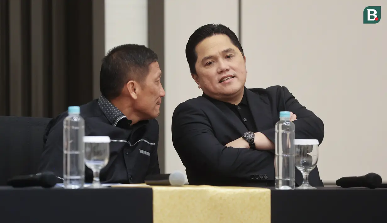 Ketua Persatuan Sepak Bola Seluruh Indonesia (PSSI), Erick Thohir, berbincang dengan Direktur Utama PT Liga Indonesia Baru (LIB) Ferry Paulus, saat jumpa pers di Menara Danareksa, Jakarta Pusat, Kamis (20/6/2024). (Bola.com/M Iqbal Ichsan)