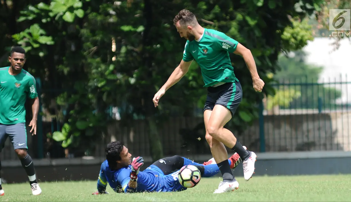 Pemain Timnas Indonesia, Ilija Spasojevic (kanan) mengecoh Muhammad Ridho saat latihan di Lapangan ABC Senayan, Jakarta, Selasa (20/2). Jelang Asian Games 2018, pemain Timnas U-23 kembali melakukan pemusatan latihan. (Liputan6.com/Helmi Fithriansyah)