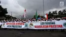 Peserta Aksi Bela Palestina membentangkan spanduk saat unjuk rasa di kawasan silang Monas, Jakarta, Minggu (17/12). MUI memimpin aksi protes keputusan Presiden AS, Donald Trump yang mengakui Yerusalem sebagai ibu kota Israel. (Liputan6.com/Faizal Fanani)
