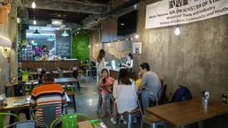 Wisatawan saat mengunjungi kafe Mao Shan Wang di distrik Chinatown, Singapura (23/1). Restoran yang menyediakan beragam aneka rasa durian ini telah menarik banyak pengunjung untuk datang mencicipi buah durian di kafe tersebut. (AFP Photo/Nicholas Yeo)