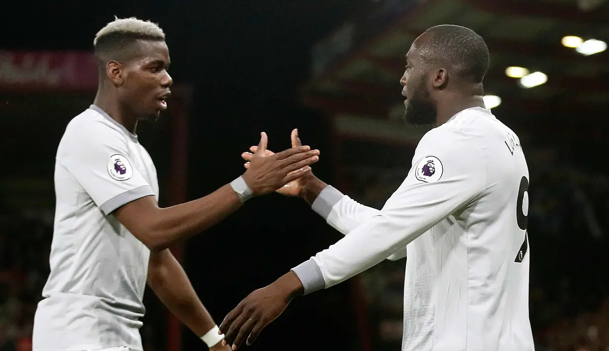 Penyerang Manchester United, Romelu Lukaku melakukan selebrasi dengan Paul Pogba usai mencetak gol ke gawang Bournemouth pada pertandingan Liga Inggris di Stadion Vitality, (18/4). MU menang 2-0 atas Bournemouth. (AP Photo/Adam Davy)