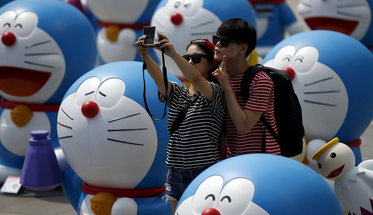 Sejumlah wisatawan saat berselfie di antara patung – patung Doraemon, Seoul, Korea Selatan,Senin (31/8/2015). Pameran ini berlangsung dari 28 Agustus sampai 4 oktober. (REUTERS/Kim Hong – Ji)