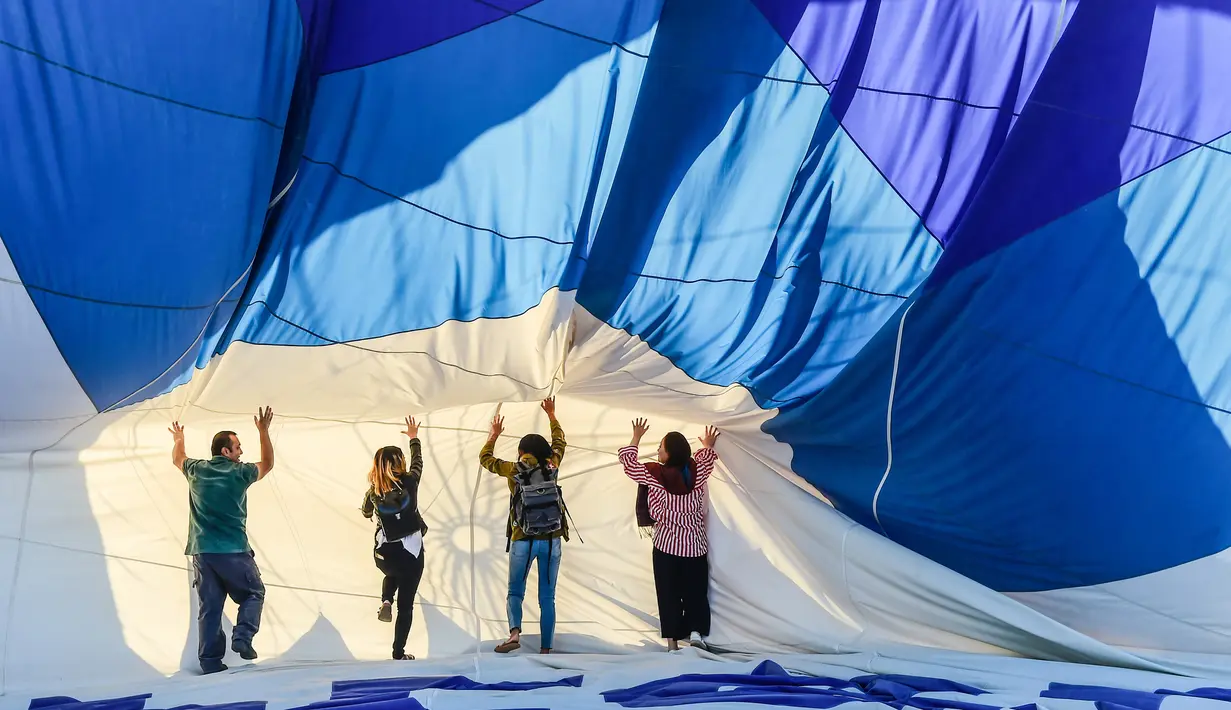 Wisatawan bersiap melakukan penerbangan dengan balon udara panas di atas Nevsehir di wilayah Cappadocia, Turki (5/9). Balon udara panas yang terbang di atas Cappadocia juga menjadi pemandangan menarik bagi para wisatawan. (AFP Photo/Yasin Akgul)