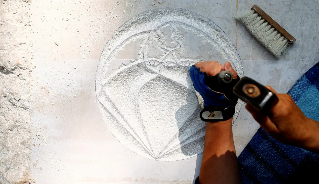 Pematung memahat di sebuah batu pada "Bosnian Pyramid of the Sun", di taman arkeologi, Visoko, Bosnia dan Herzegovina, (27/7). Piramida memancarkan gelombang ultrasonik. (REUTERS/Dado Ruvic)