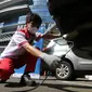 Teknisi melakukan uji emisi pada uji emisi gratis Asuransi Astra, di Jakarta, Minggu (12/12/2021). Sebanyak 400 mobil berusia diatas 3 tahun dari berbagai merk ikuti uji emisi untuk mengetahui kinerja mesin dan tingkat efisiensi pembakaran dalam mesin kendaraan bermotor. (Liputan6.com/Fery Pradolo)